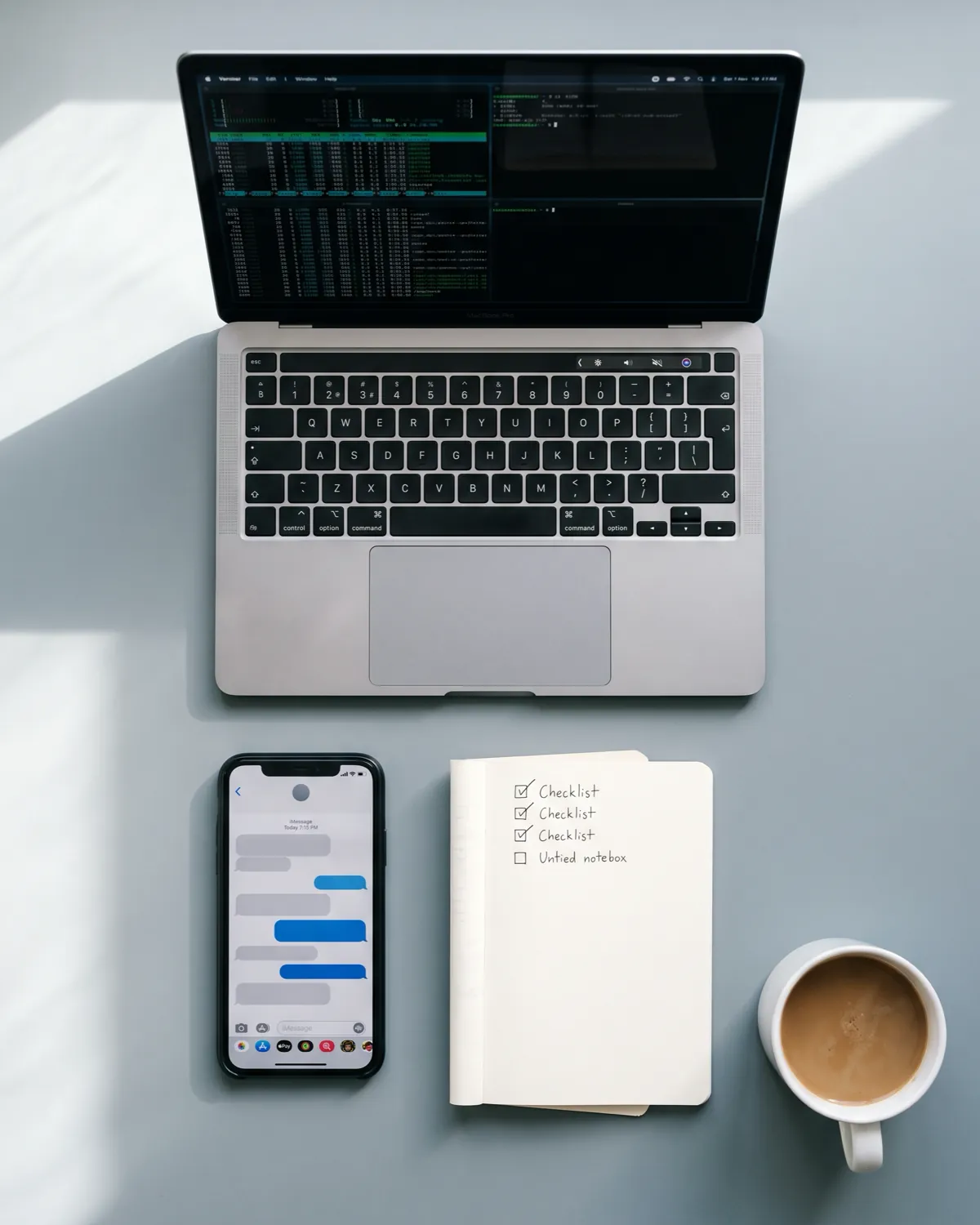 Illustration: a desk seen from above, with a laptop, a phone, a notebook with a checklist and a coffee.